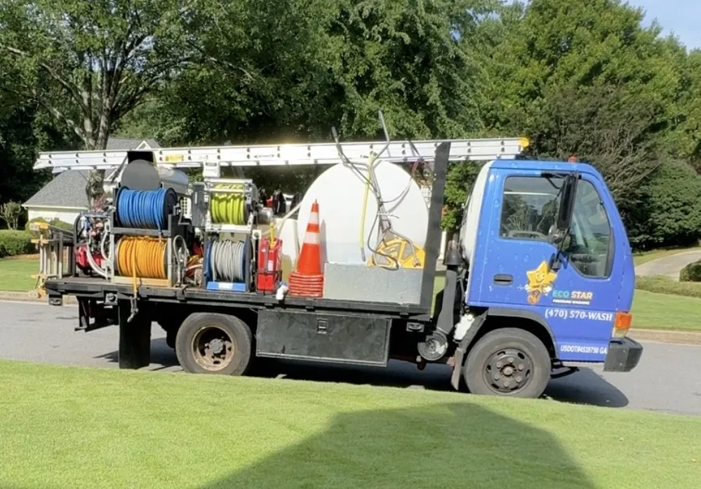 The Eco Star flatbed truck with its water tank, hose reels and ladder, parked on a customer's street
